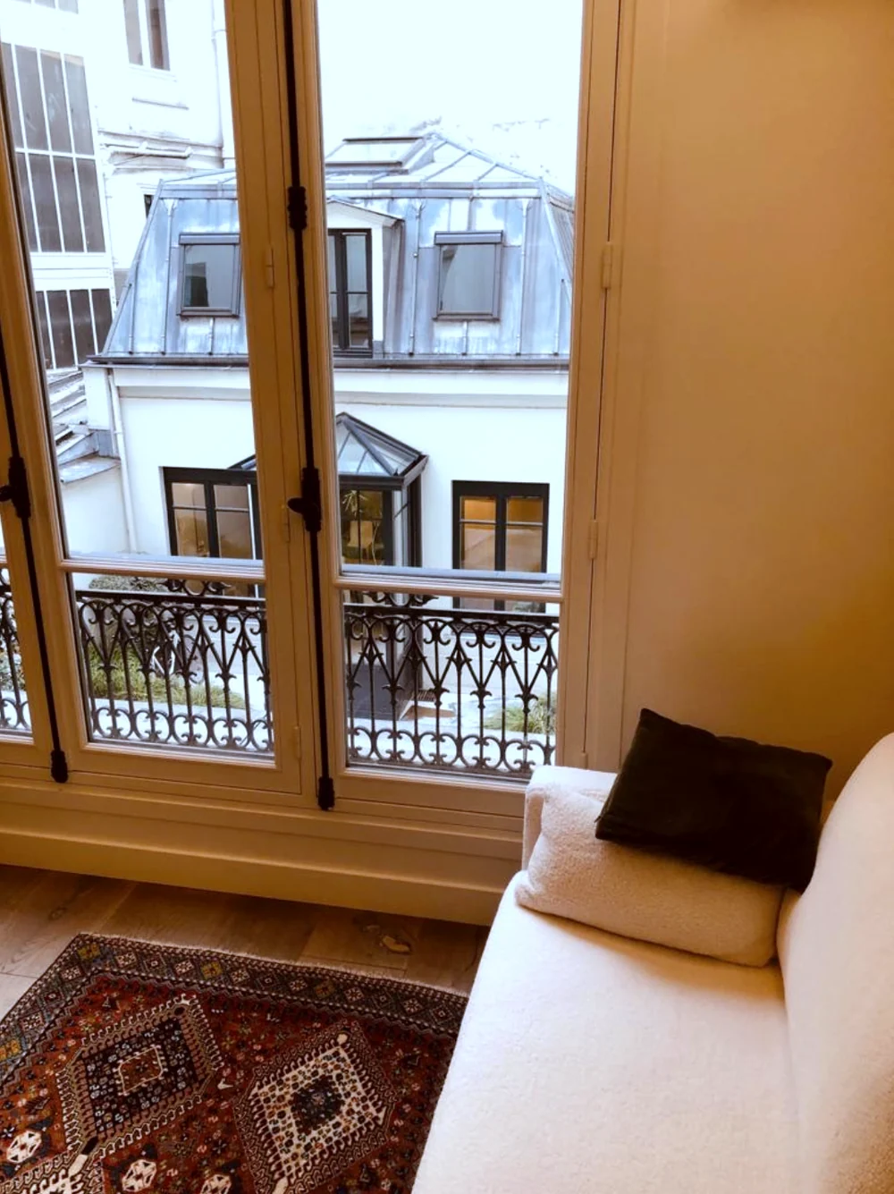 Salon du centre, canapé et fenêtre sur les toits de Paris