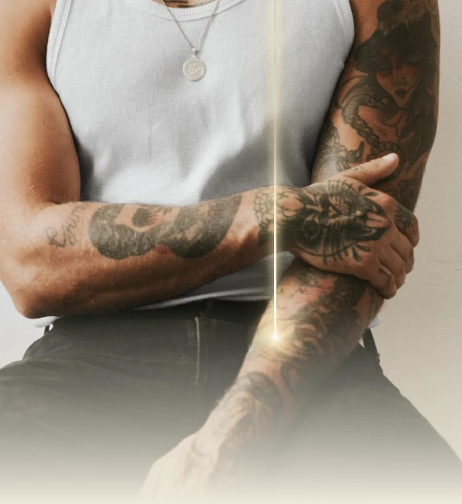 Gros plan sur un avant-bras tatoué traversé par un faisceau laser stylisé