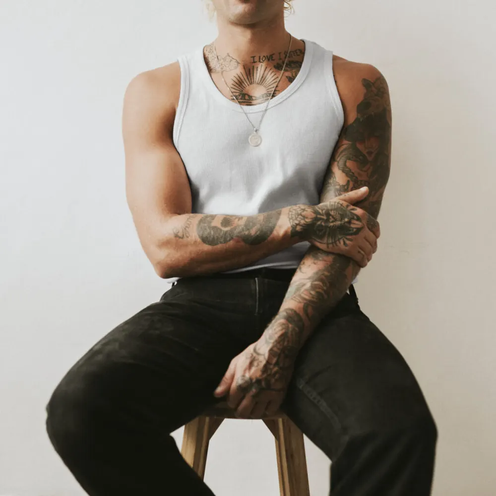 Homme tatoué assis sur un tabouret